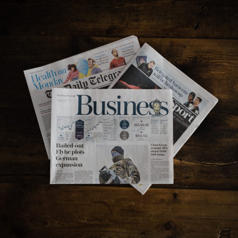 a pile of newspapers lying on a wooden floor