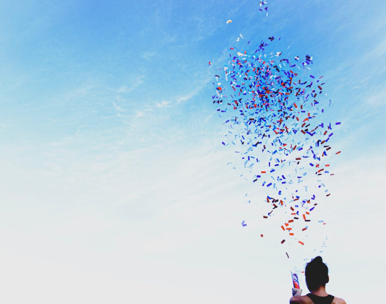 woman celebrating by opening a confetti cannon