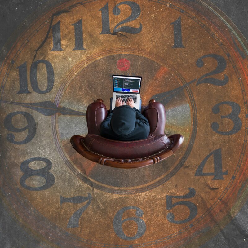 a person outsourcing life admin while sat at a laptop over a picture of a clock