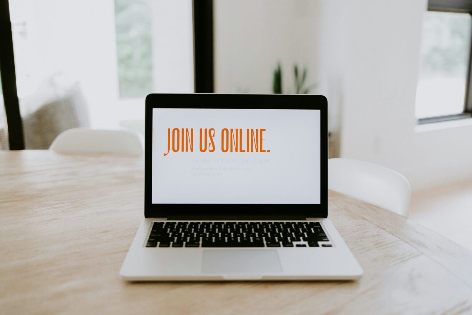 View of a laptop in a table top, with the words Join Us Online written on the laptop screen to hint at selling in your sleep via online courses