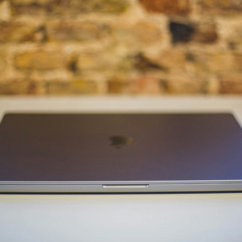 A view of a desk against a wall with a closed laptop on it to represent going through an inbox detox