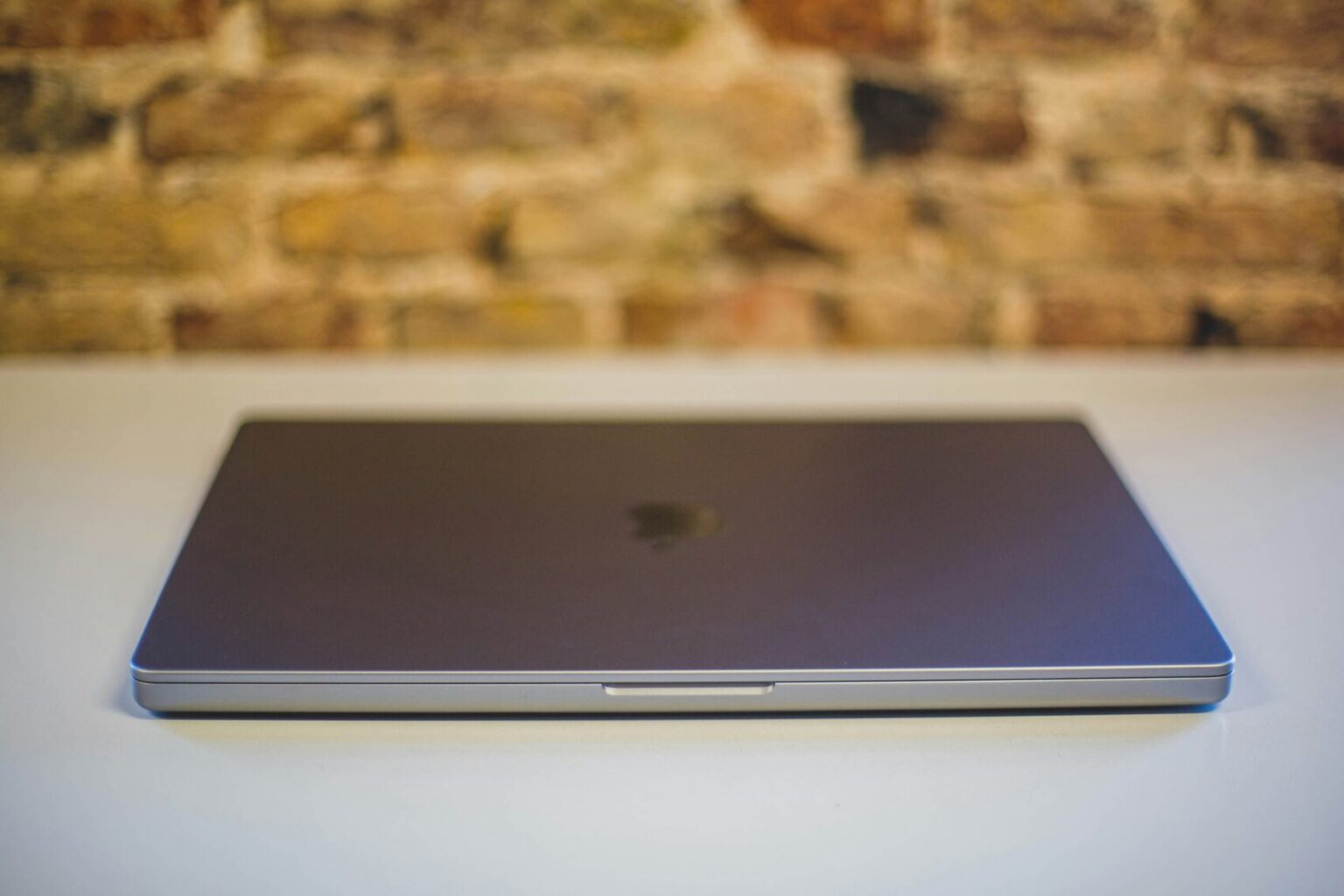 A view of a desk against a wall with a closed laptop on it to represent going through an inbox detox